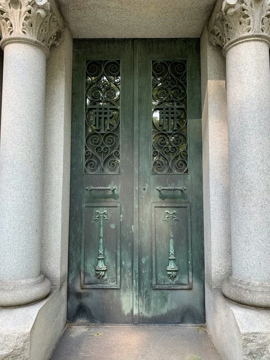 an old gray door with double arched glass