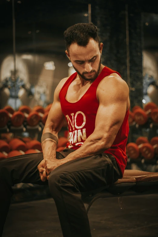 a man in red shirt and black pants sitting on bench