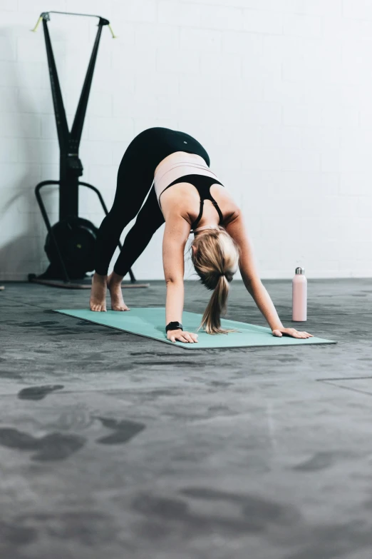 a young woman is practicing on her yoga mat