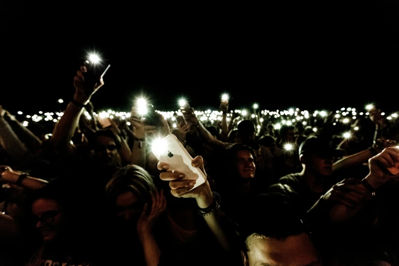 people in a crowd holding their cell phones