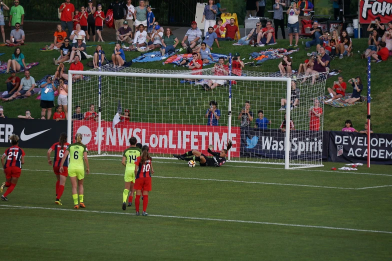 a group of soccer players congregates near the goal