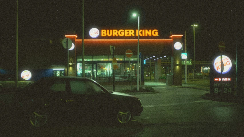 there are signs that say burger king at night time