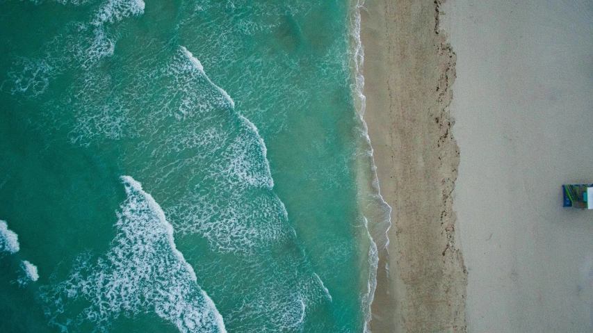 a beach with a green water and sandy beach