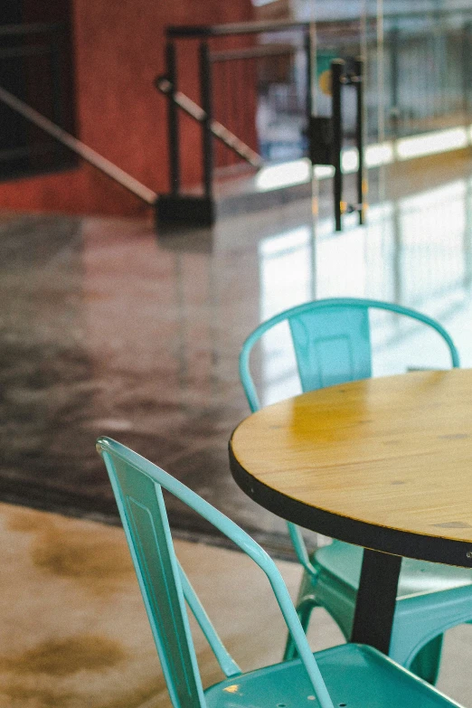 a table and chair sit outside a red wall