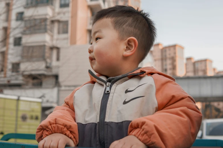 a child is sitting in a park bench with his hand on his hips