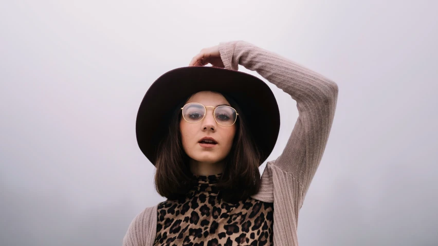 a woman wearing sunglasses, a sweater and hat