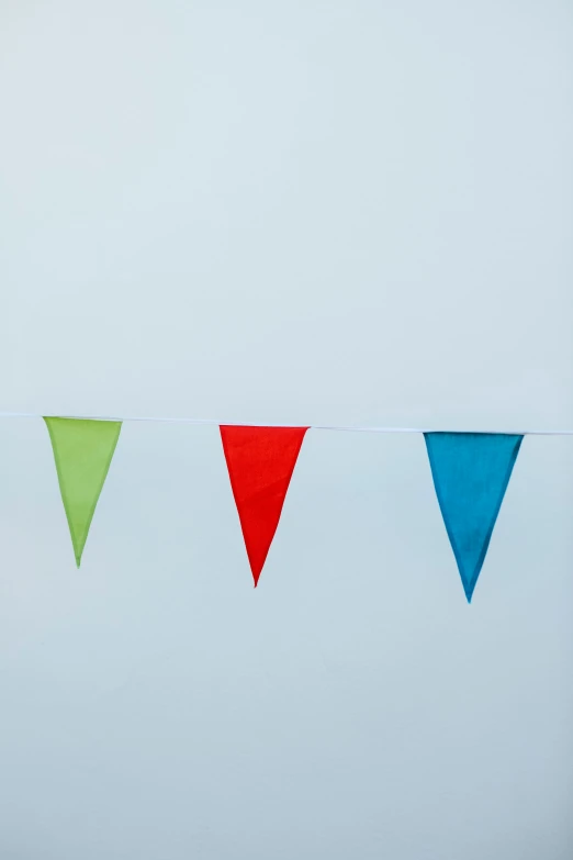 three red and one green flags hanging on line