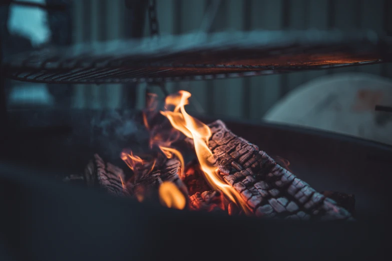 flames coming from a grill with food in it