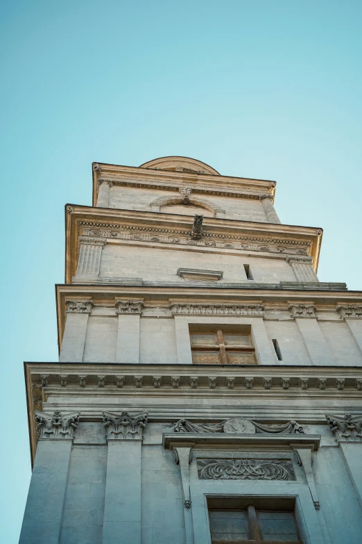 a tall clock tower with intricate carvings and blue sky