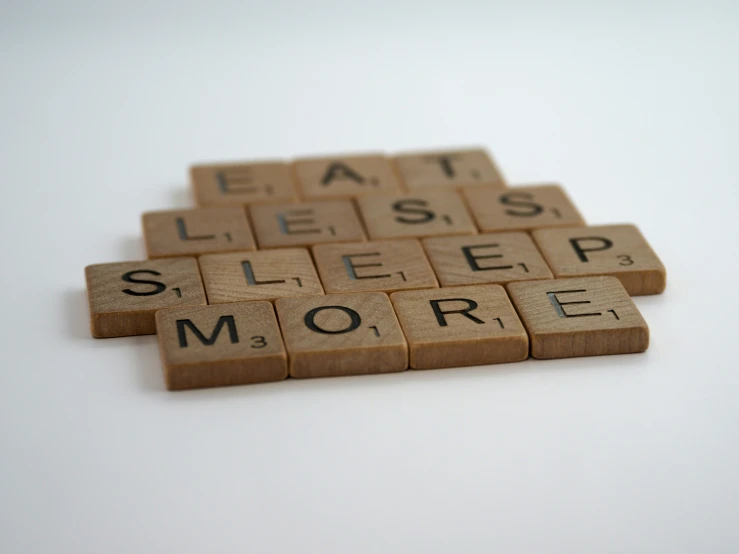 several scrabble tiles spelling the words eat sleep and more