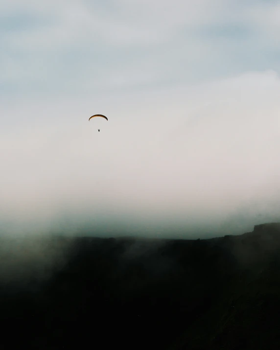 the kite is flying through the fogy sky