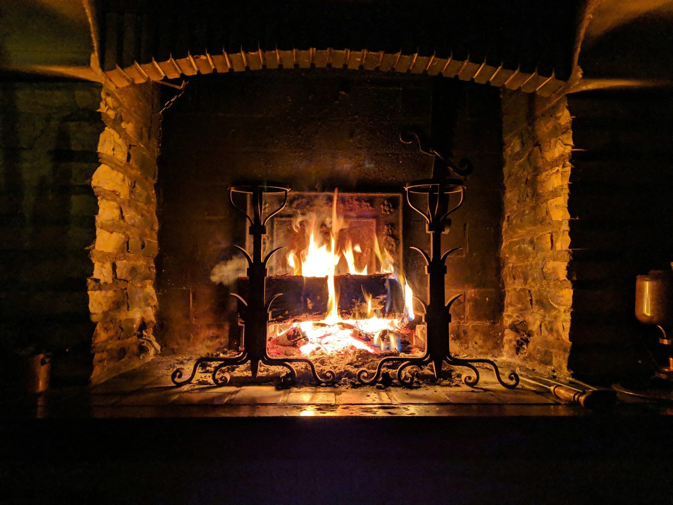 the fireplace in a stone building has flames