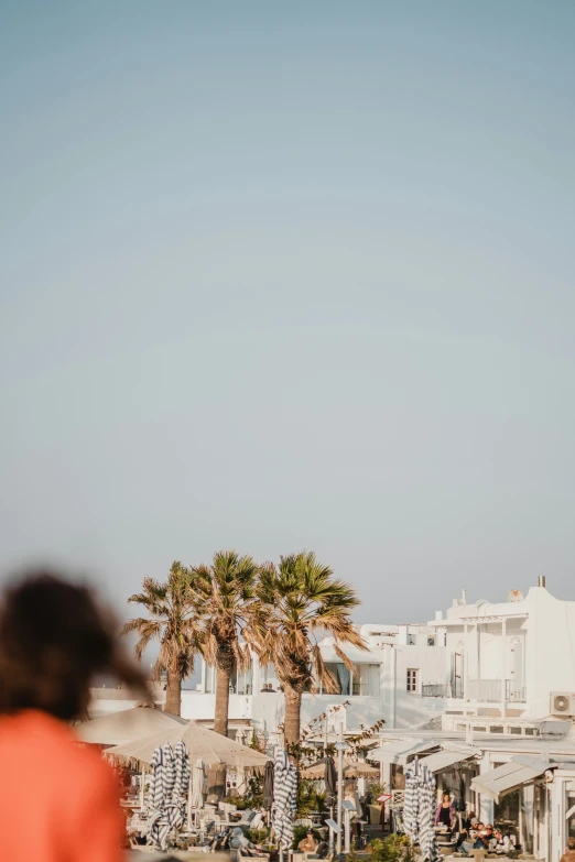 the woman is standing on the balcony in front of the building