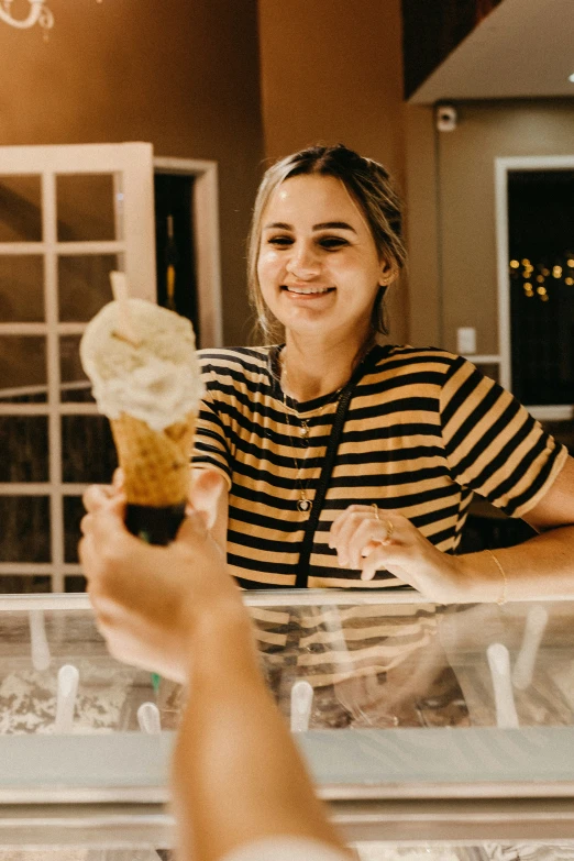 a smiling girl eating an ice cream in a cone