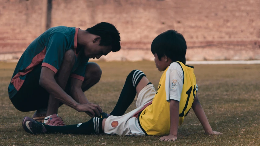 a man helping a  in a soccer field