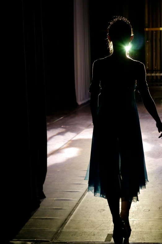 the back light is visible as she walks down the runway