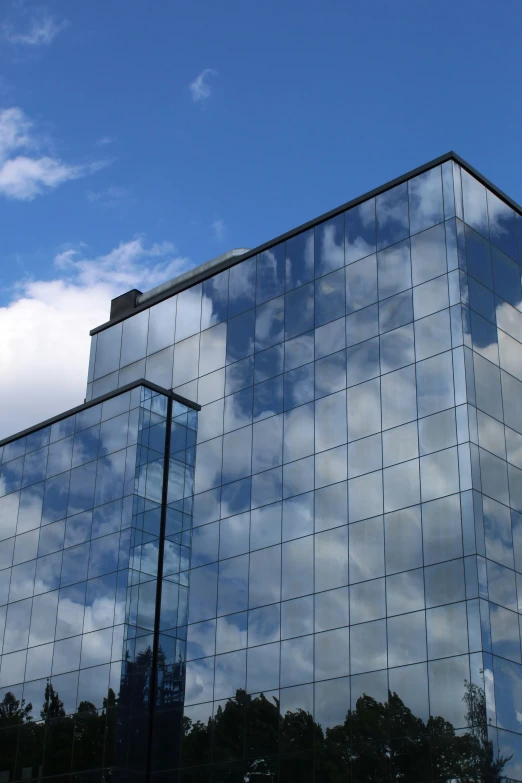 a building with blue skies reflecting on the front and the outside windows