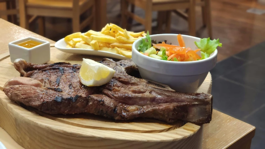 meat and vegetables on a  board with dipping sauces