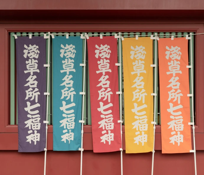 a colorful banner in front of a window reading, chinese