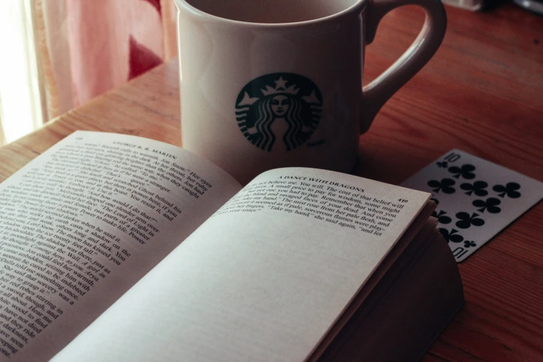 open book with starbucks logo on the left and matching playing cards in background