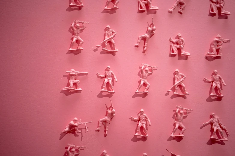 a po of tiny toy soldiers on pink background