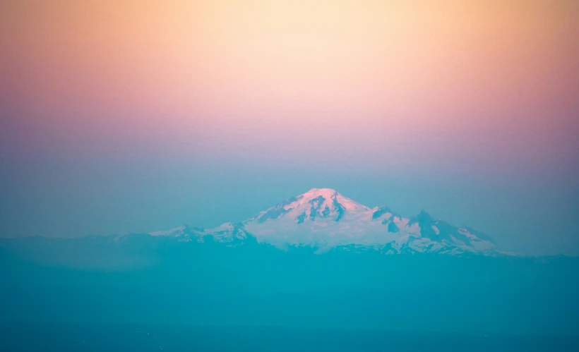 a large mountain is seen with an orange glow