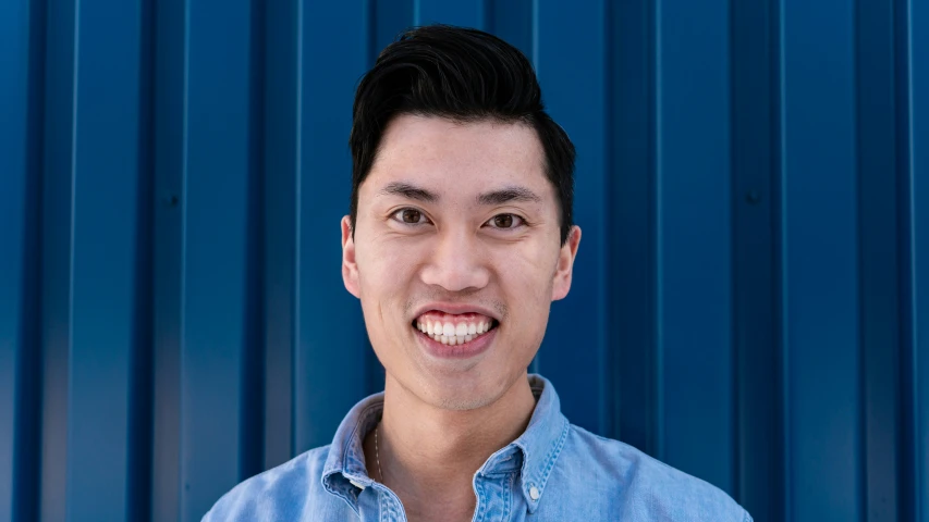 a man in front of a blue corrugated wall