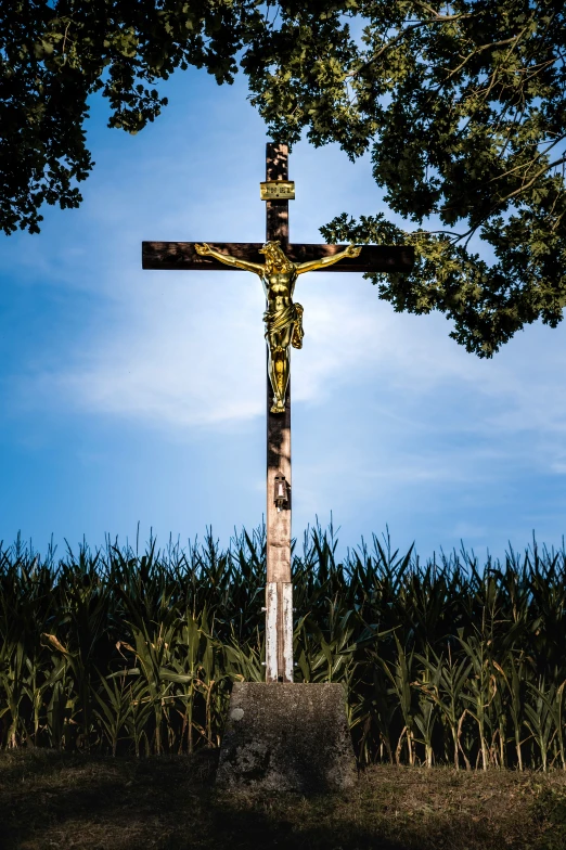 a cross sitting on the ground beside a field