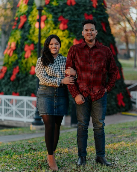 a young couple smile at the camera during their christmas portraits