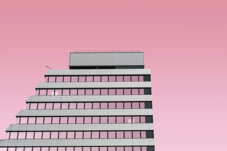 a tall skyscr on a pink sky with its reflection in the windows