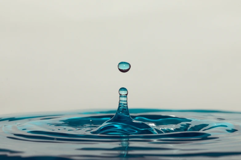 a drop of blue liquid from above it is making the image appear to be quite large