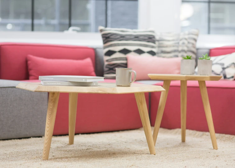 a coffee table between two modern wooden tables