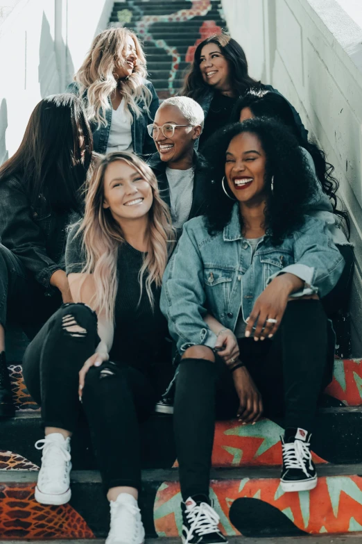 several women sitting on steps with their arms around each other