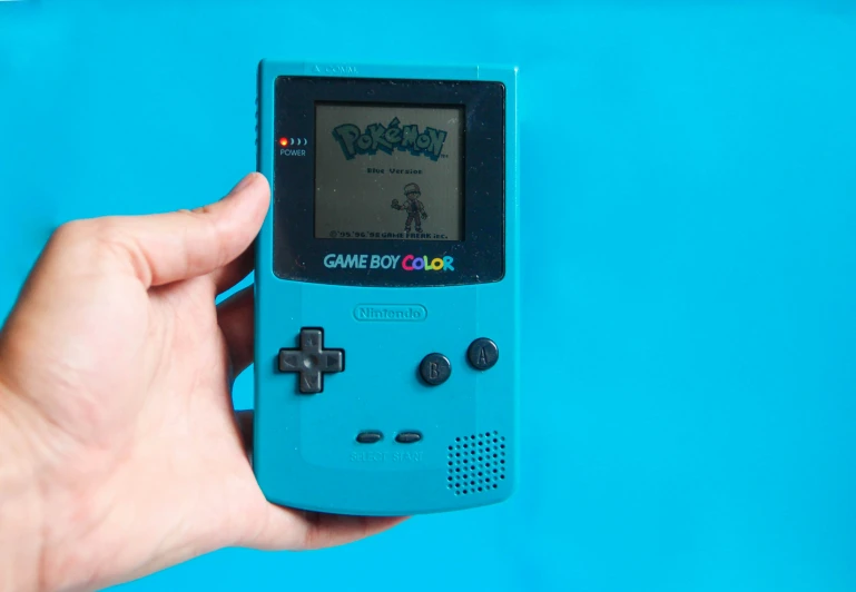 someone is holding an old nintendo gameboy with the game boy color