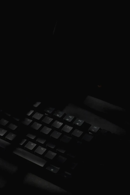 a computer keyboard illuminated by the dark night