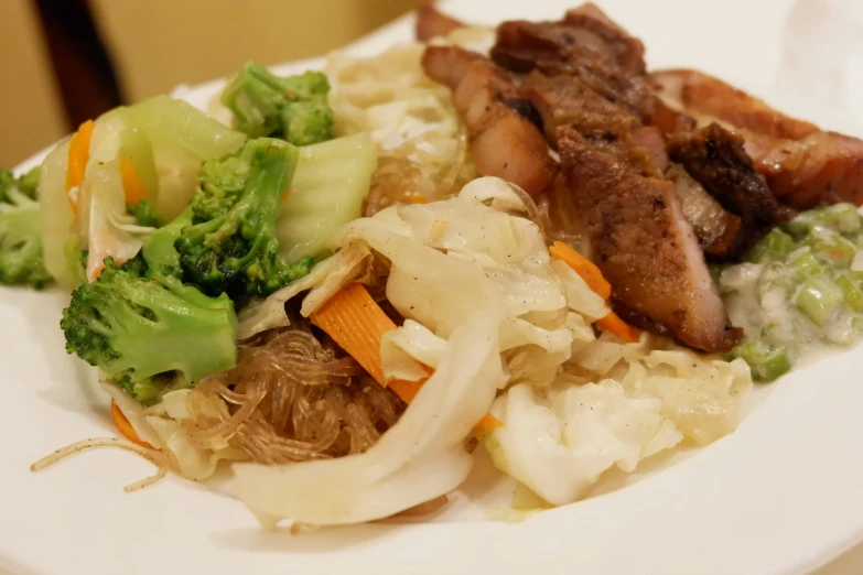 a plate with some meat and vegetables on it