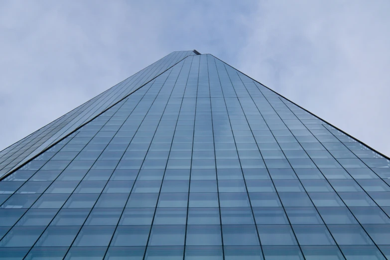 a view of the side of a tall building, glass