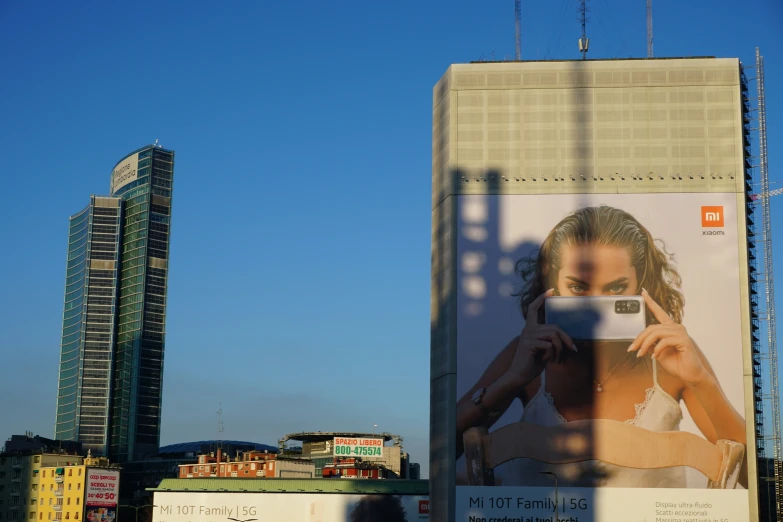 a huge building with a woman holding a cell phone