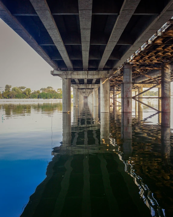 the view under a bridge with a reflecting lake in it