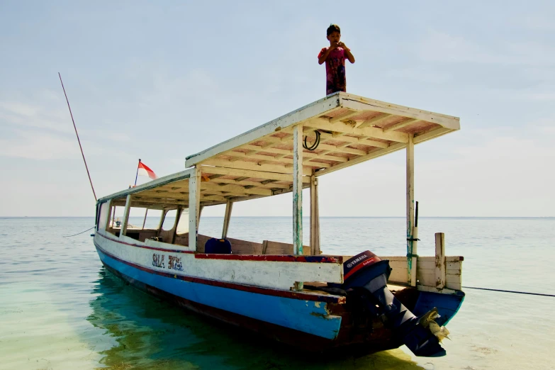 a man standing on the top of a boat in the ocean