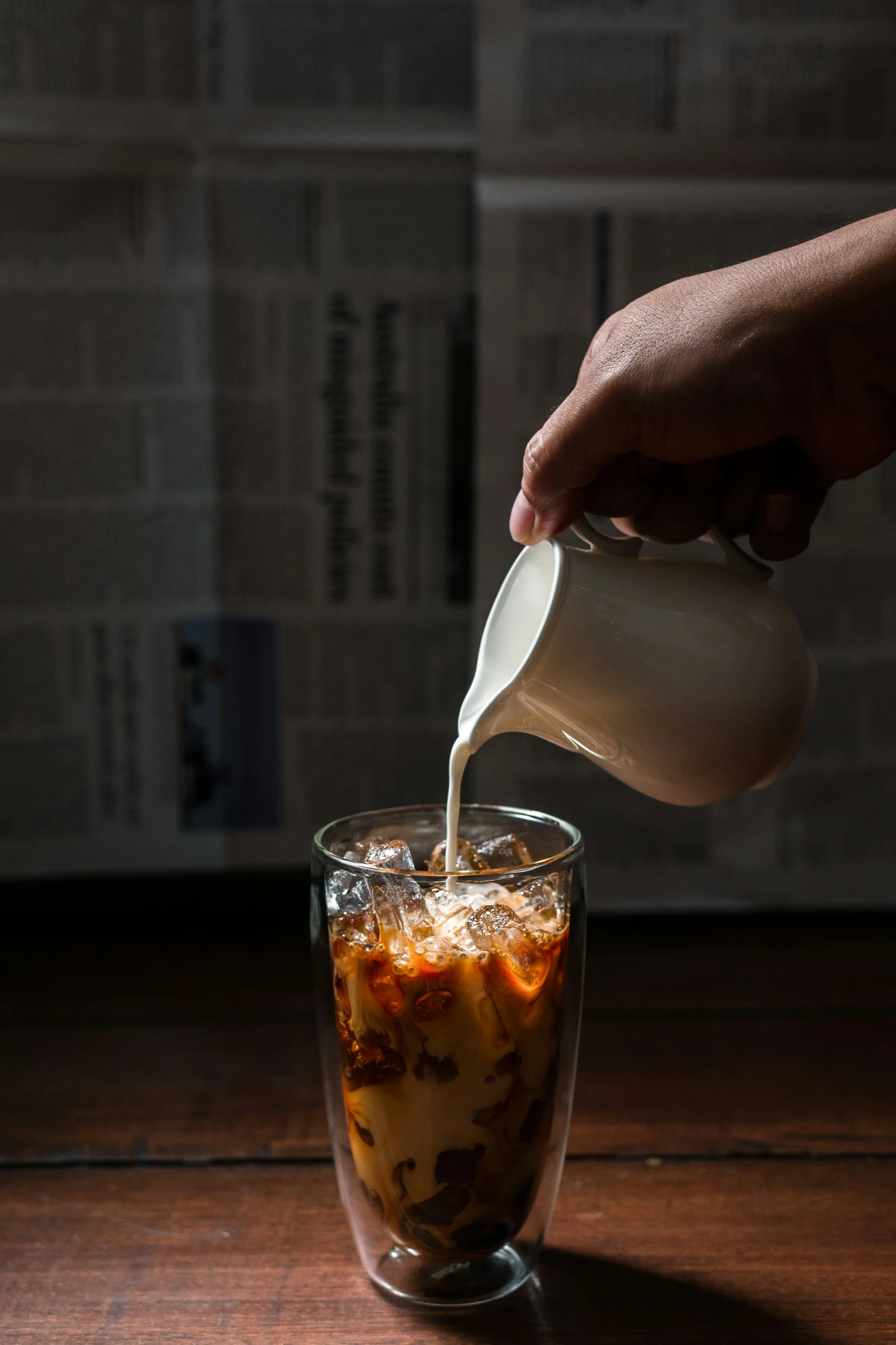 a person pours white sauce into a glass