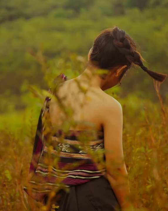 a woman is standing in the tall grass