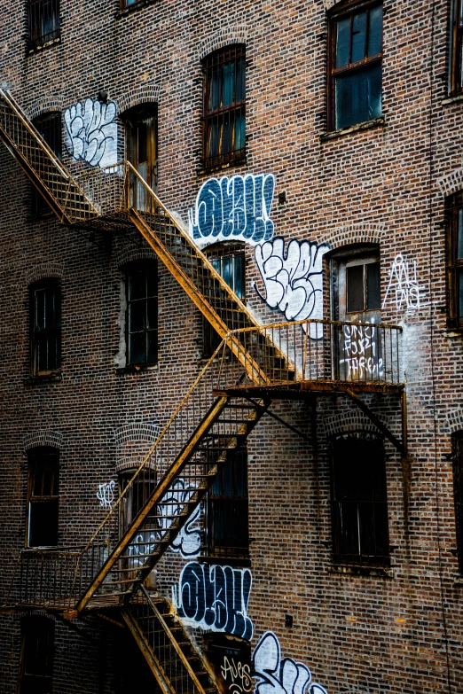 the exterior view of a building with graffiti and open windows