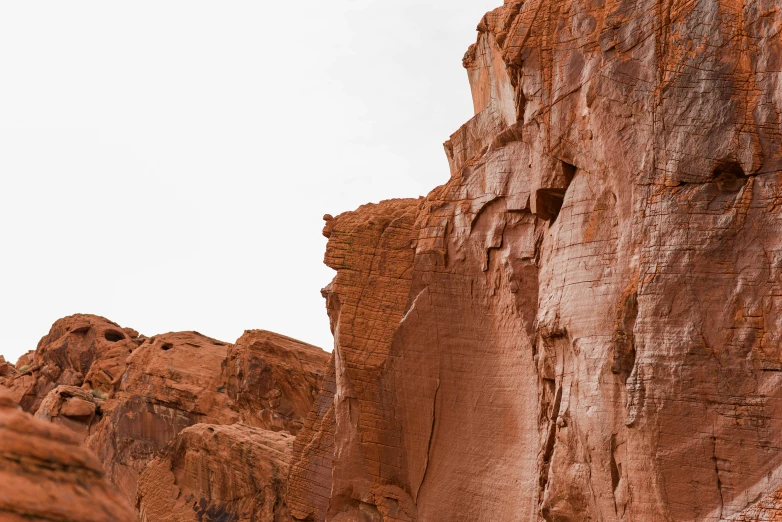 large red rock formation with very little trees