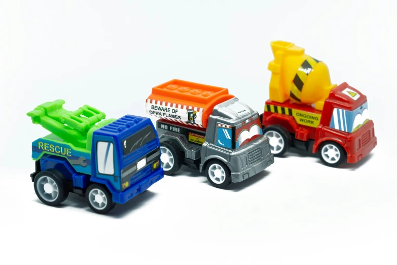 three plastic trucks in different designs on white background