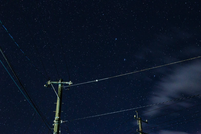 a telephone pole sits under the stars