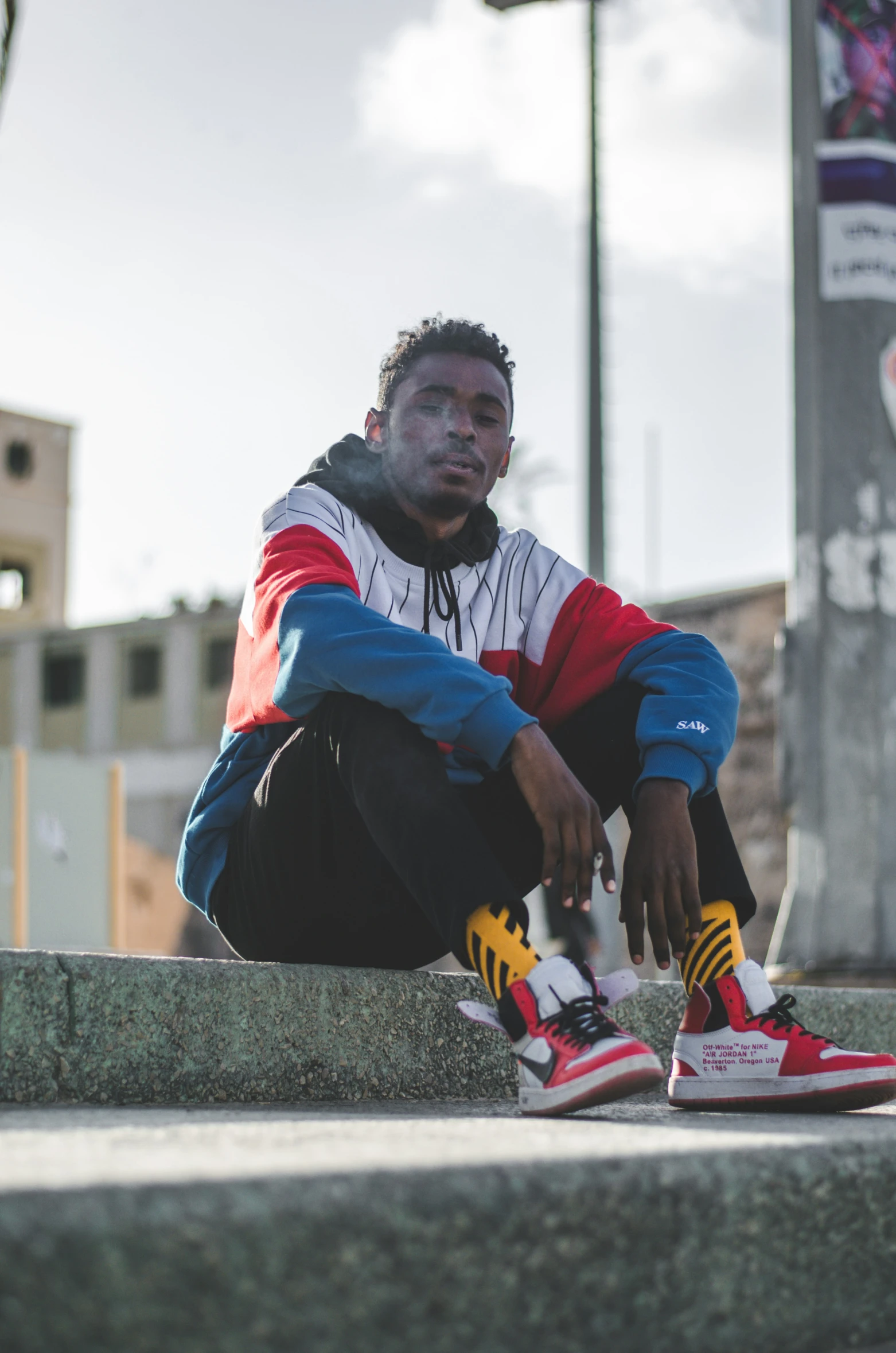 a man sitting on the steps wearing sneakers