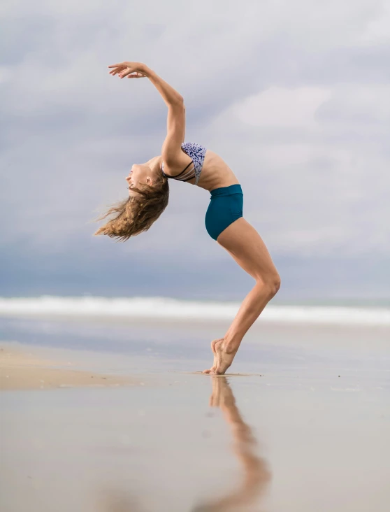 a woman is practicing yoga by the water