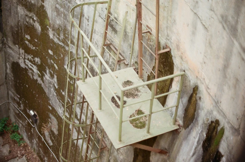 an ironing ladder sitting next to a green wall