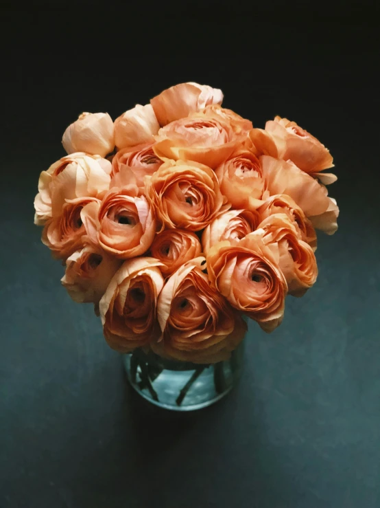 a vase is holding a bouquet of peach colored roses